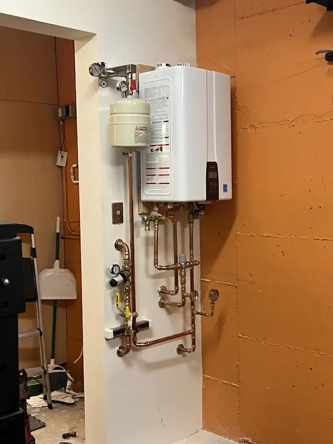 Plumbing technician inspecting water heater connections in Tamiami